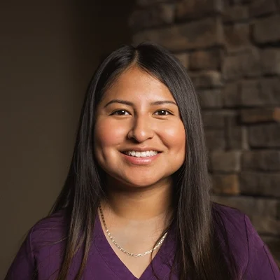 Massage Therapist Marisol T. In Front Of Blurred Wall
